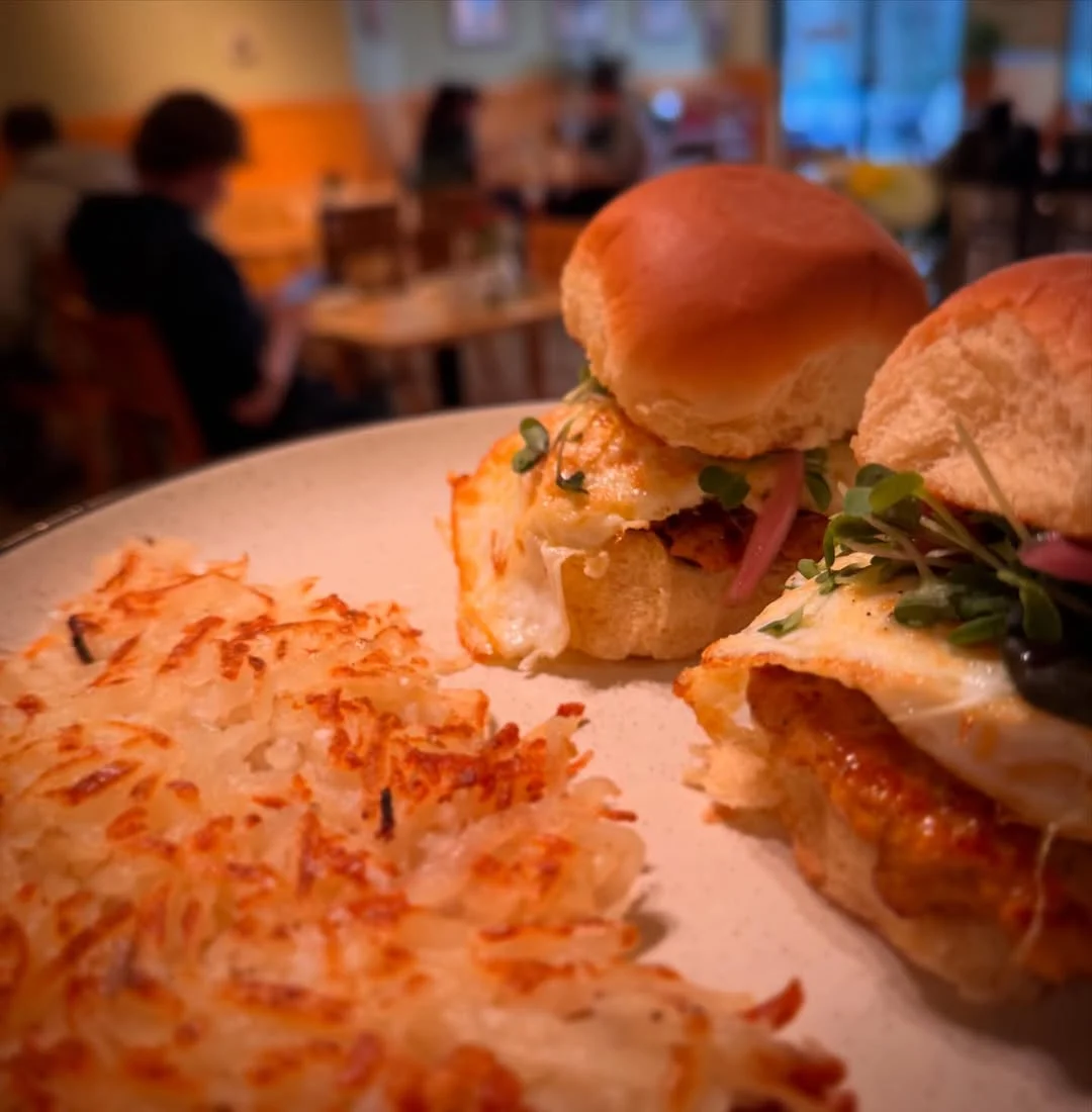 Chicken sausage sliders with fried egg and microgreens served with crispy hash browns